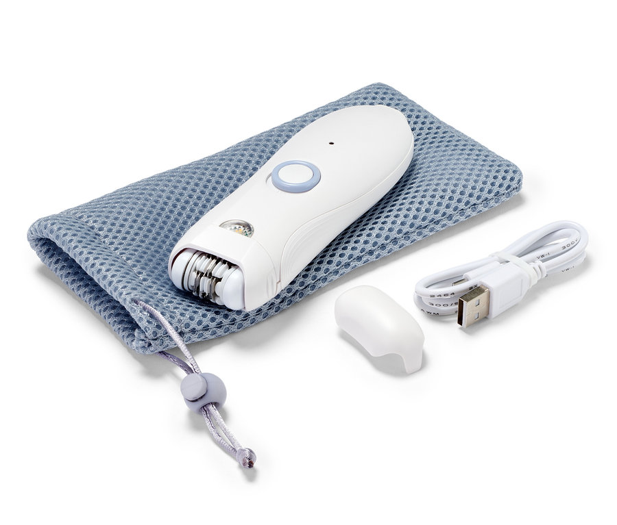 Un épilateur pour le visage blanc repose sur une pochette bleue à cordon de serrage à côté d'un câble de chargement et d'un capuchon.