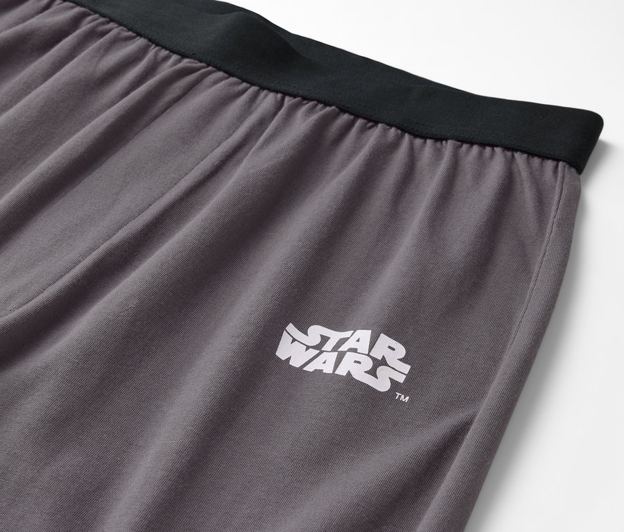 Détail d'un pantalon gris avec une ceinture noire et un logo Star Wars.