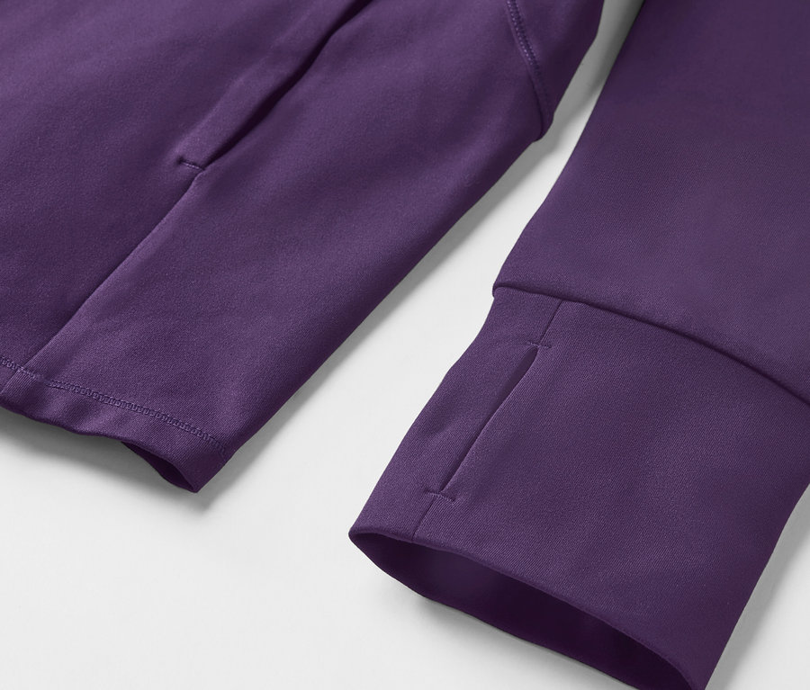 Gros plan sur un sweat-shirt violet à manches longues avec des trous pour les pouces et une poche sur le bras.