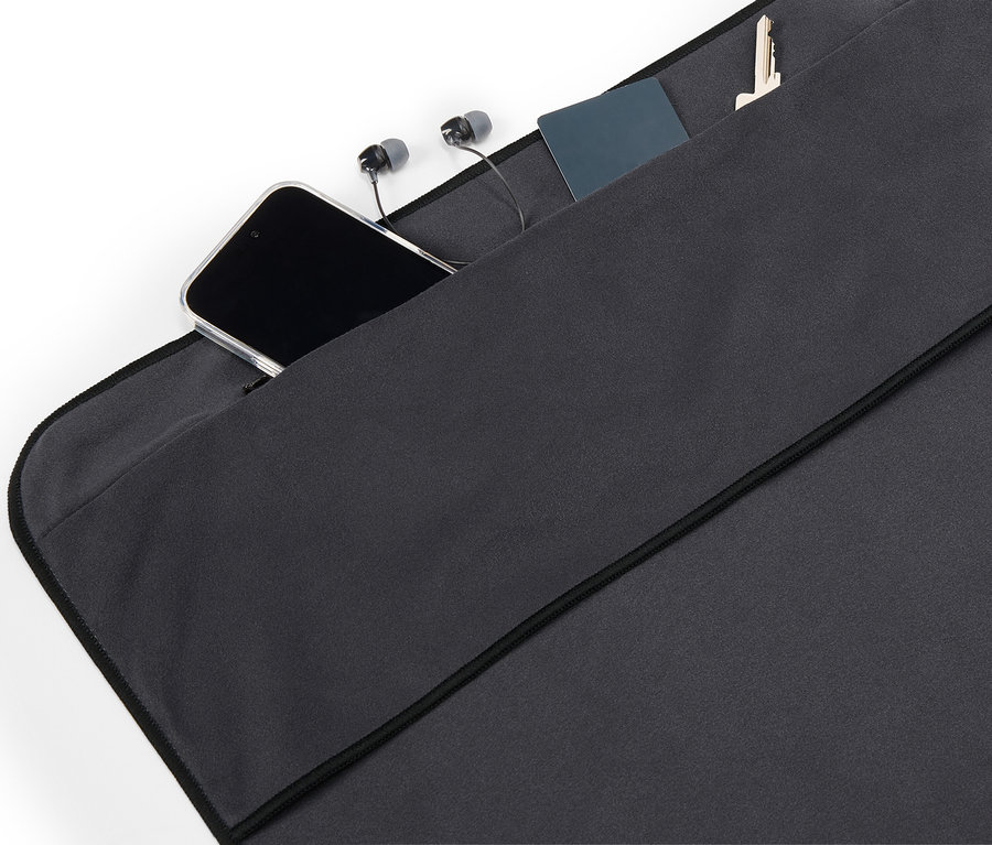 Dans la poche en tissu noir se trouvent un téléphone portable, des écouteurs, une carte et une clé.