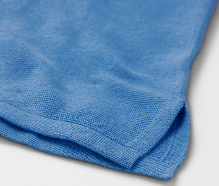 Détail d'un pull en maille bleu ciel.