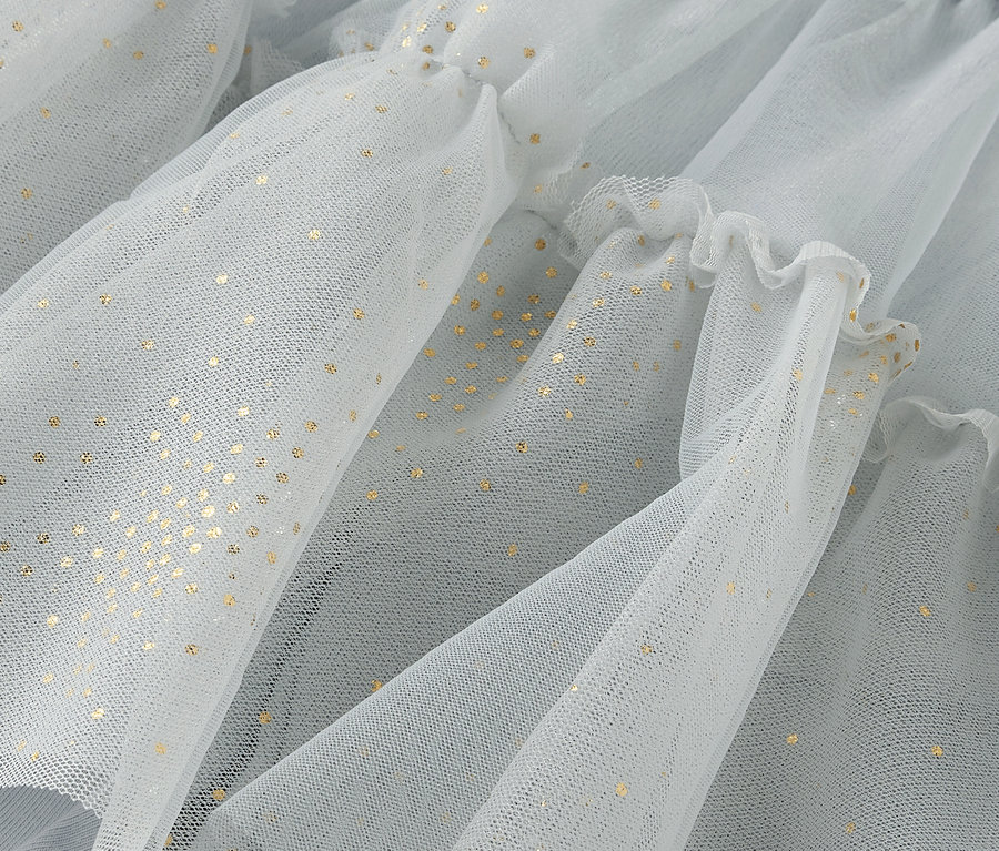Gros plan sur un tissu en tulle bleu clair avec des points dorés et des volants.