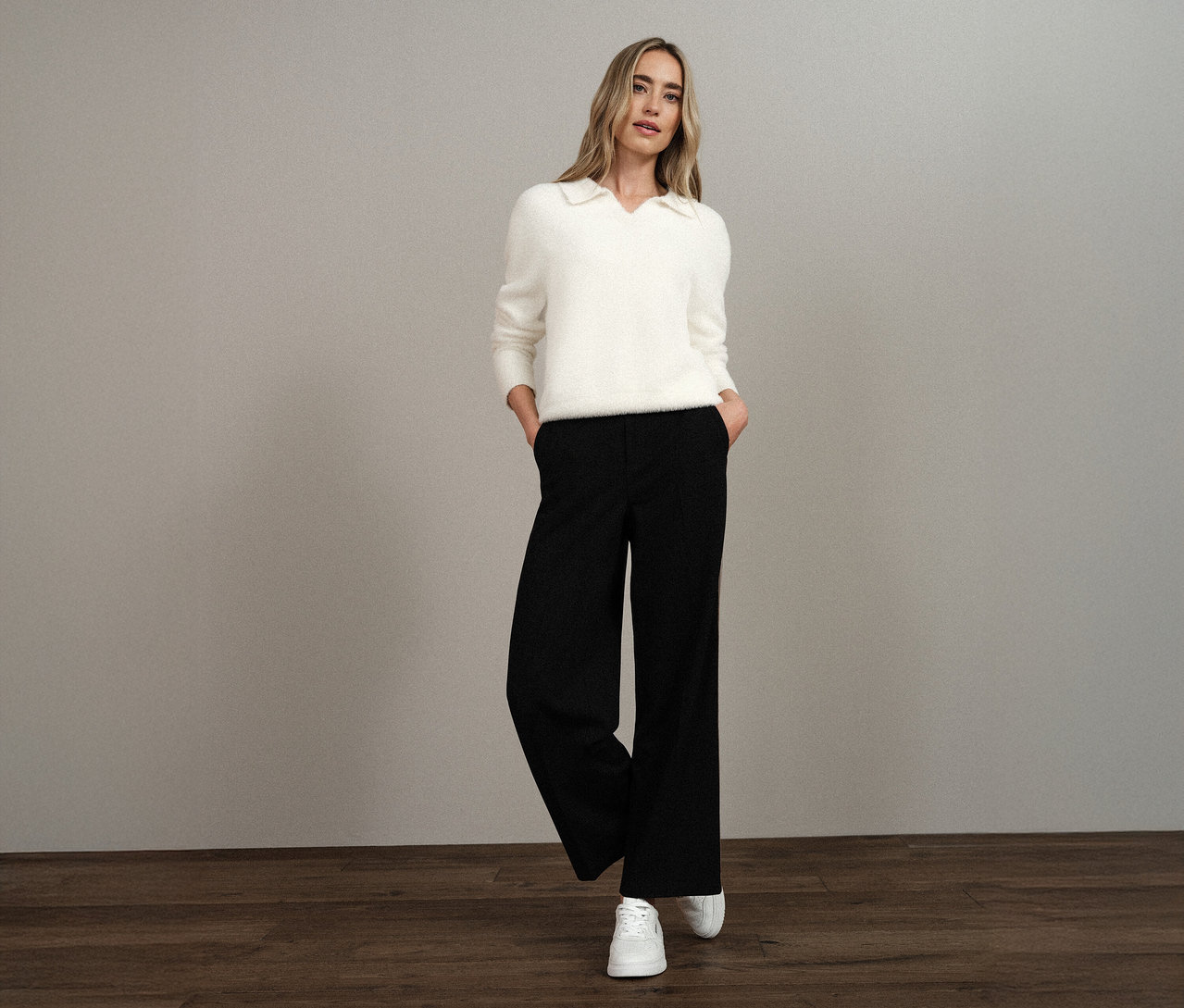 Femme portant un pull en maille à col polo Street One blanc, un pantalon noir et des baskets blanches.