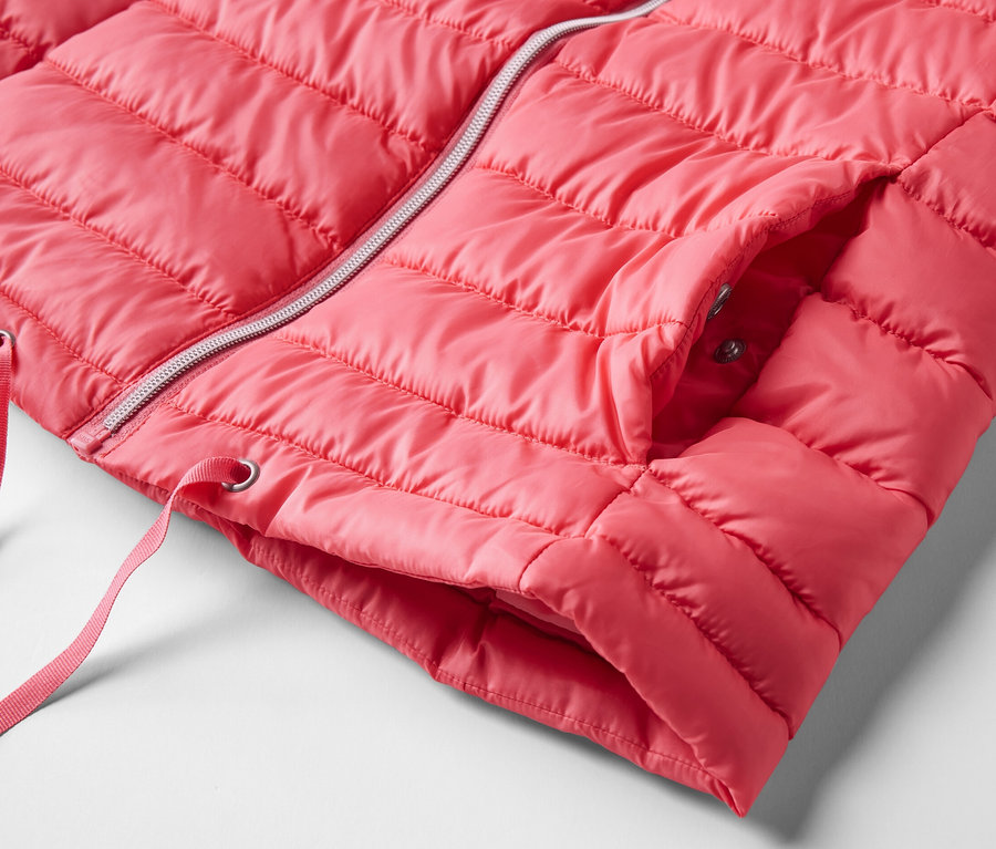 Détail d'un gilet sans manches matelassé à capuche rose avec une fermeture éclair argentée.