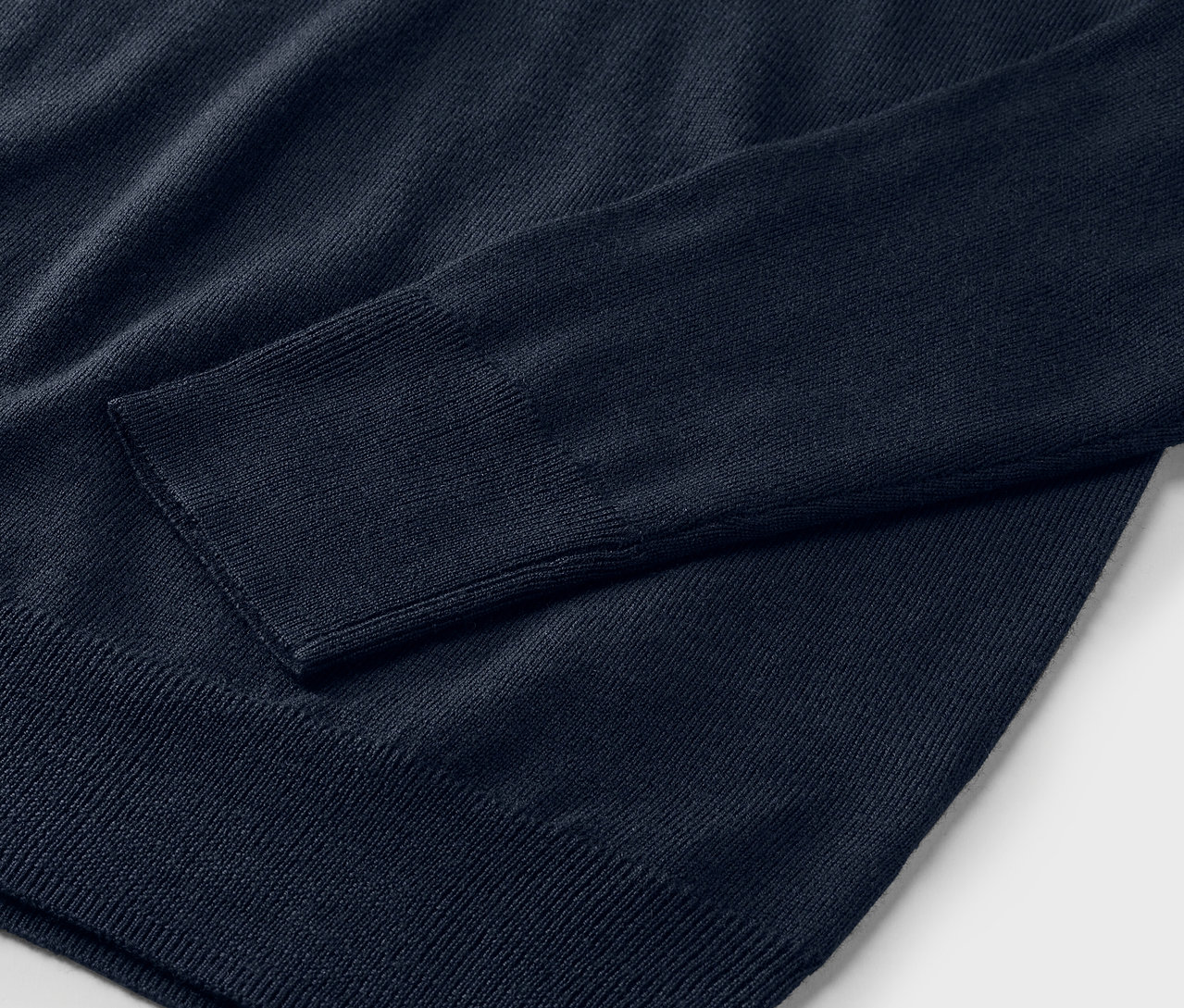 Gros plan sur un pull en maille fine mérinos bleu marine.