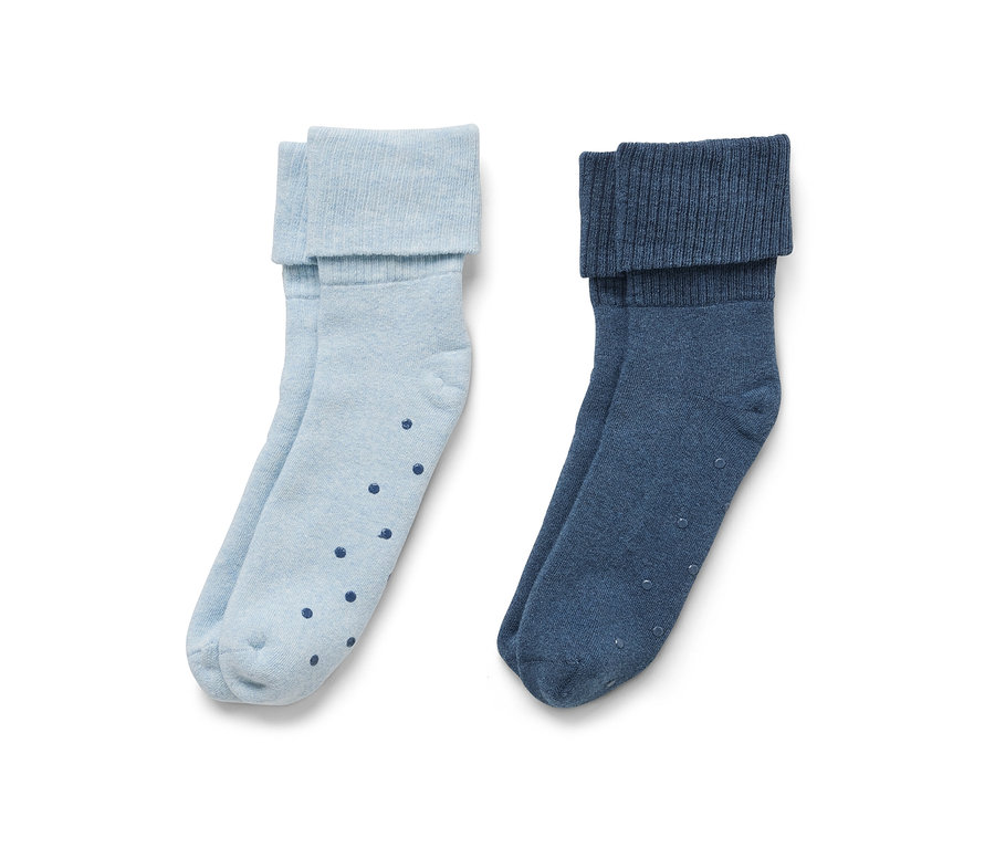 Deux paires de chaussettes antidérapantes : une paire bleu clair avec des points bleu foncé, et une paire bleu foncé.