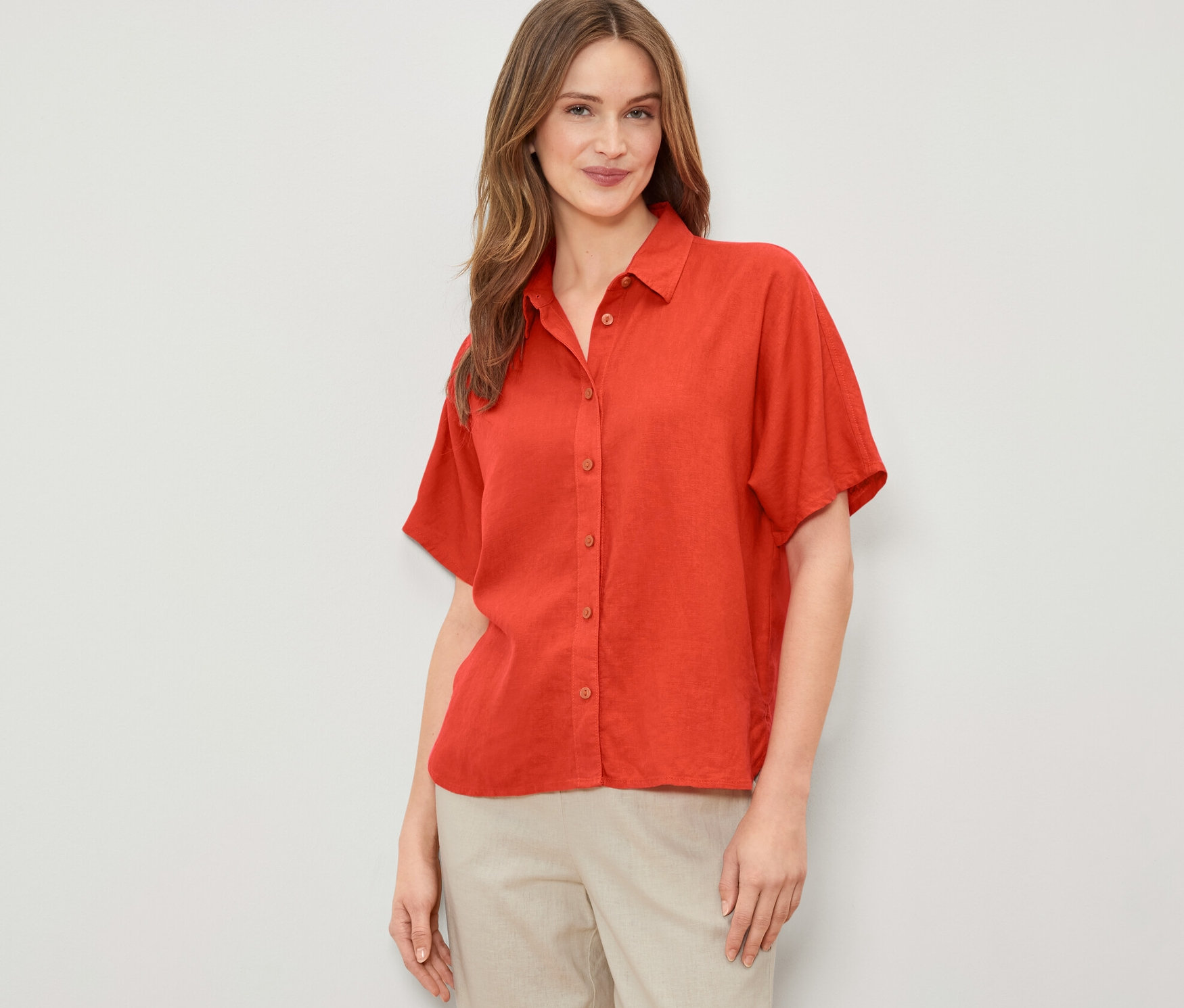 Une femme portant un chemisier en lin orange.