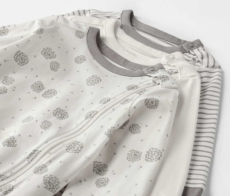 Trois pyjamas pour bébé avec motifs de pissenlits et rayures.
