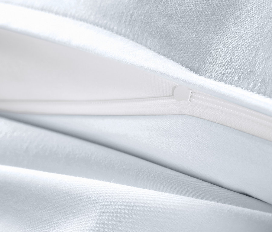 Gros plan d'une parure de lit en satin de coton blanc grande taille avec fermeture éclair ouverte.