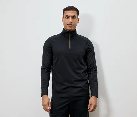 Un homme porte un t-shirt noir à manches longues avec une fermeture éclair au niveau du cou.