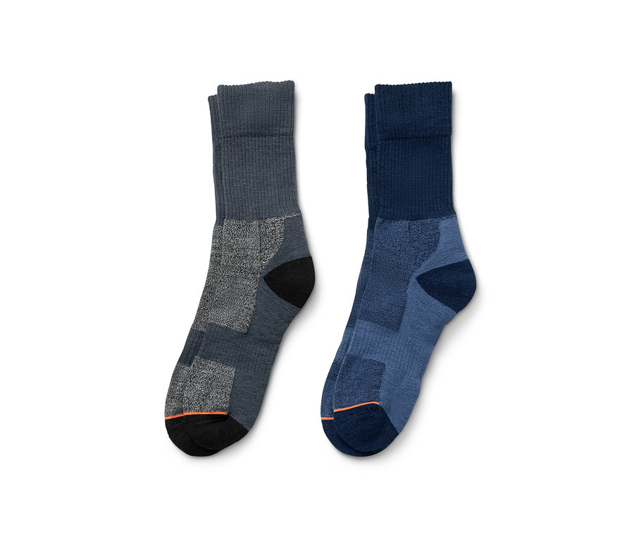 Deux paires de chaussettes de trekking en laine mérinos, une paire grise et une paire bleue.
