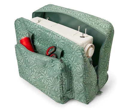 Sac de machine à coudre ouvert à motif floral avec une machine à coudre, une bobine de fil rouge et des ciseaux à l'intérieur.