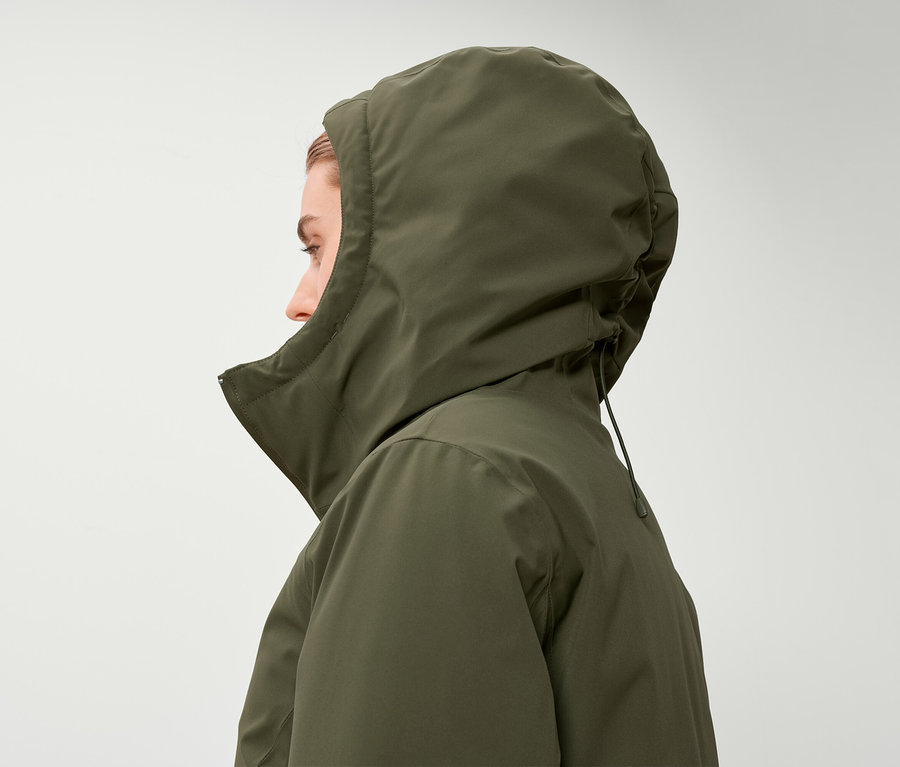 Profil d'une femme portant une veste à capuche vert olive.