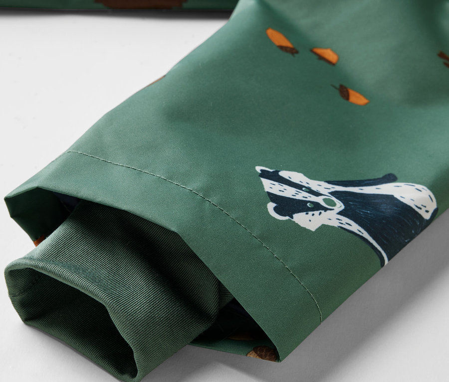 Détail d'une veste de pluie thermique pour enfant avec un motif d'animaux de la forêt.