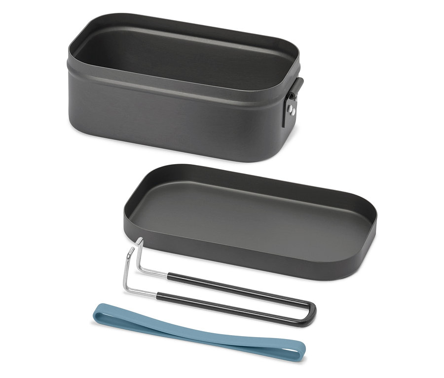 Une boîte à lunch ouverte, rectangulaire, gris foncé avec un couvercle, un support et un élastique bleu est posée sur un fond blanc.