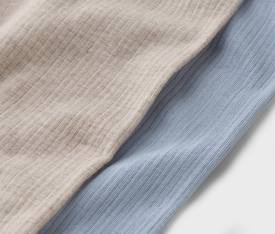 Gros plan de deux morceaux de tissu : un beige et un bleu clair.