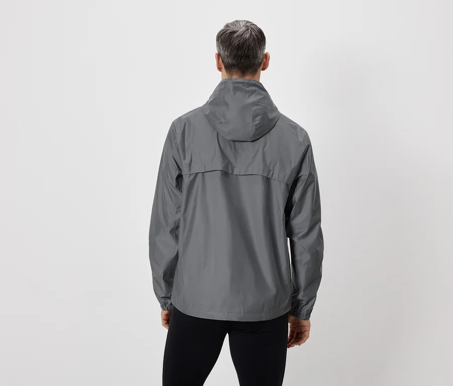 Vue arrière d'une personne aux cheveux gris portant un imperméable gris à capuche et un pantalon noir sur fond blanc.