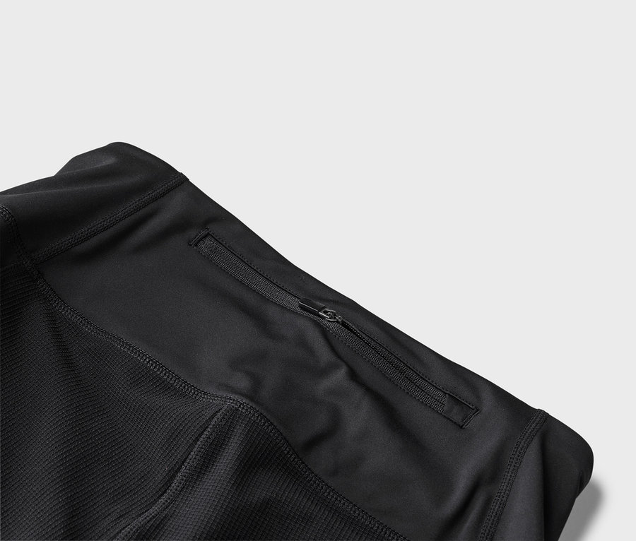 Vue détaillée d'une veste de sport noire avec une poche zippée.