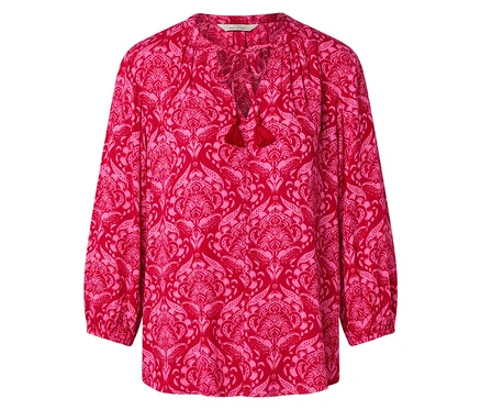 Chemisier rouge à motif floral rose avec des pompons à l'encolure.