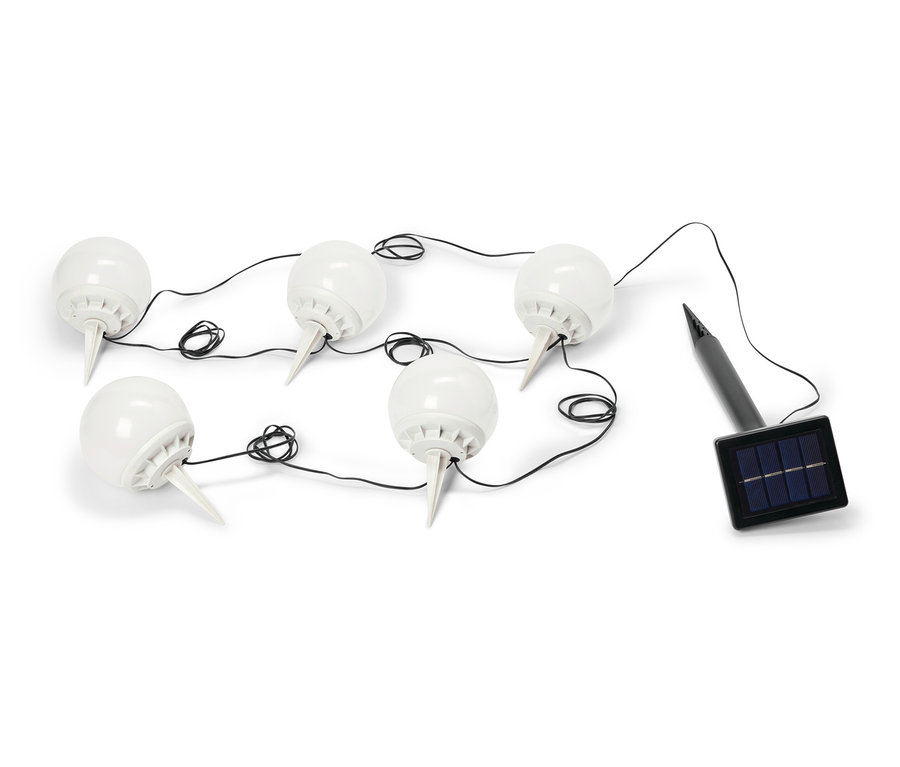 Six lampes de jardin sphériques blanches sont reliées par un câble noir menant à un petit panneau solaire noir.