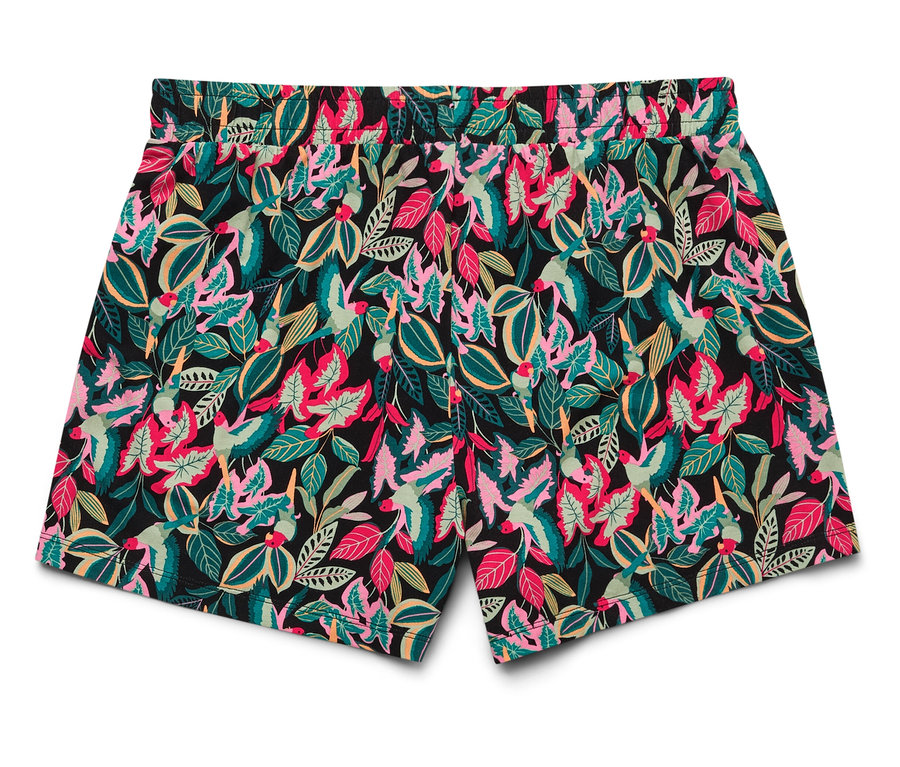Un short avec un fond noir et un motif de feuilles roses, vertes et jaunes est posé sur un fond blanc.