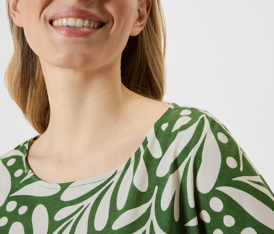 Gros plan d'une femme portant un haut à motifs verts et blancs.