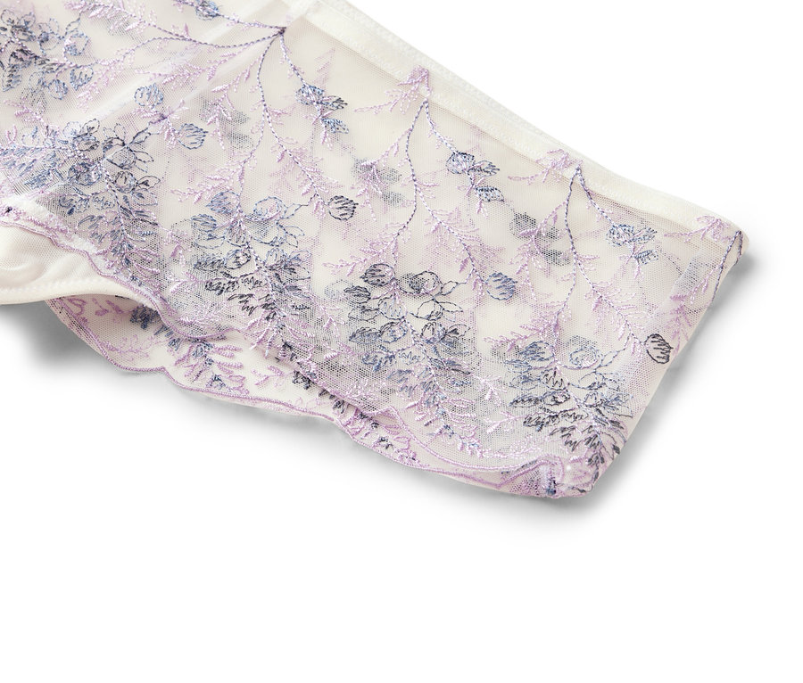 Gros plan d'une culotte en dentelle blanche avec des broderies florales violettes et bleues.