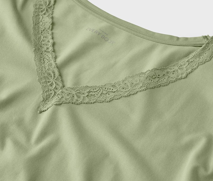 Gros plan sur un t-shirt vert clair avec un col en V orné de dentelle.