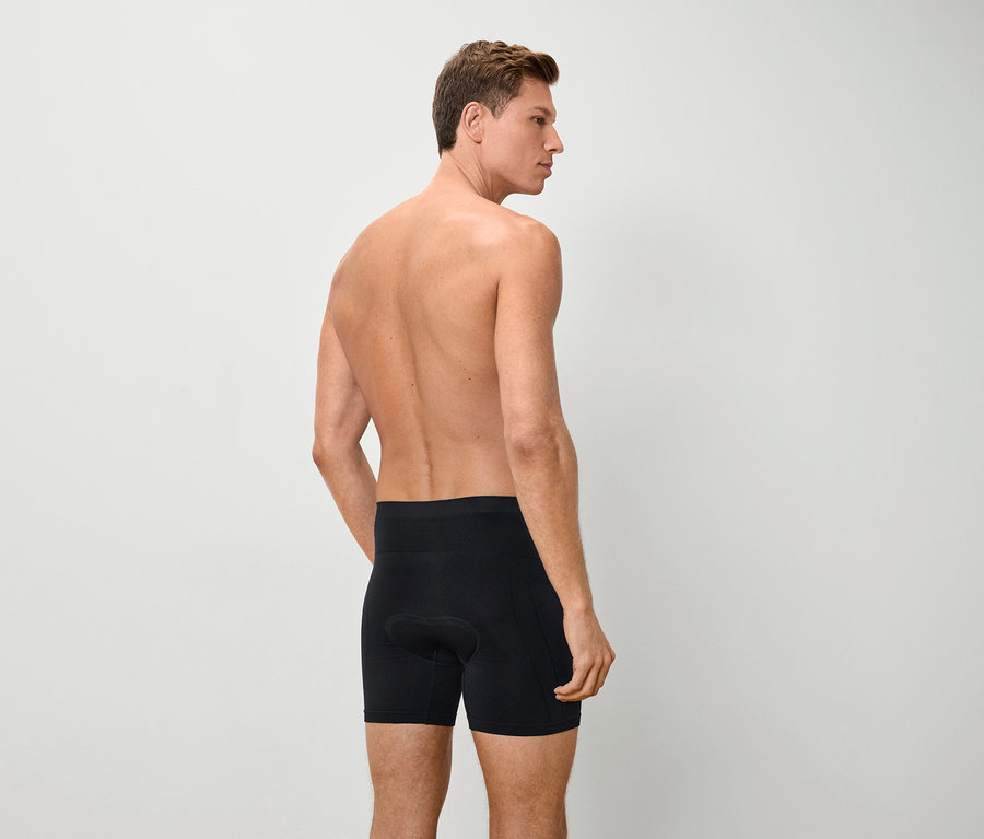 Vue arrière d'un homme torse nu portant un boxer noir.