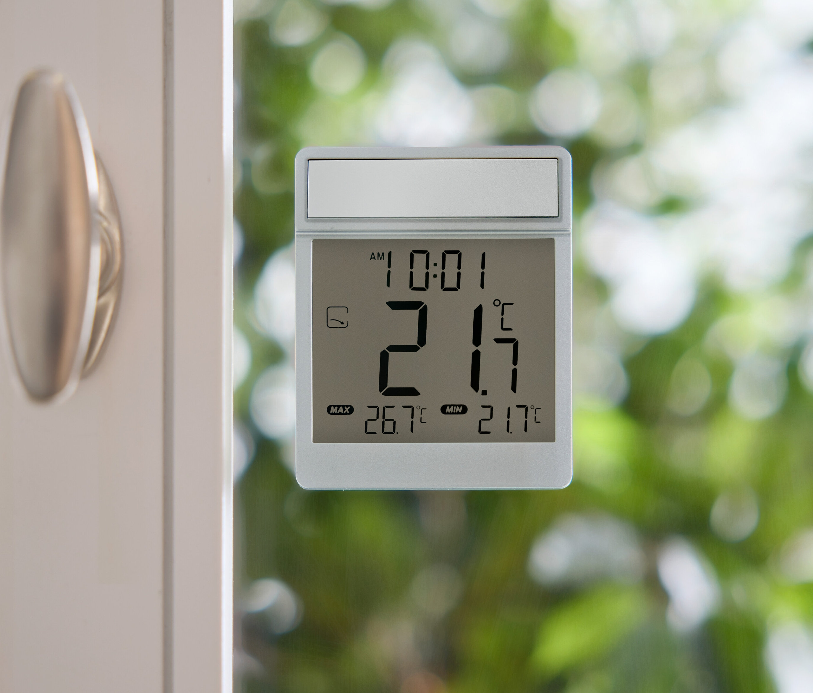 Thermomètre numérique indiquant 21,7 degrés Celsius sur une vitre.