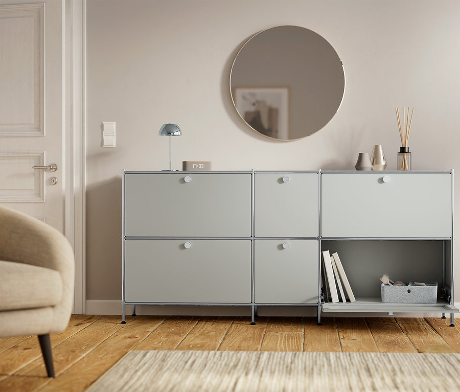 Un meuble gris à six compartiments est placé à côté d'une porte et d'un fauteuil.