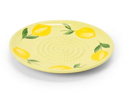 Une râpe en céramique jaune avec un motif de citron repose sur un fond blanc.