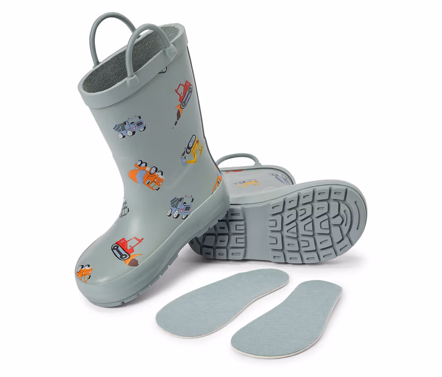 Une paire de bottes de pluie pour enfants bleu clair avec des motifs de chantier et des semelles intérieures sont posées sur un fond blanc.