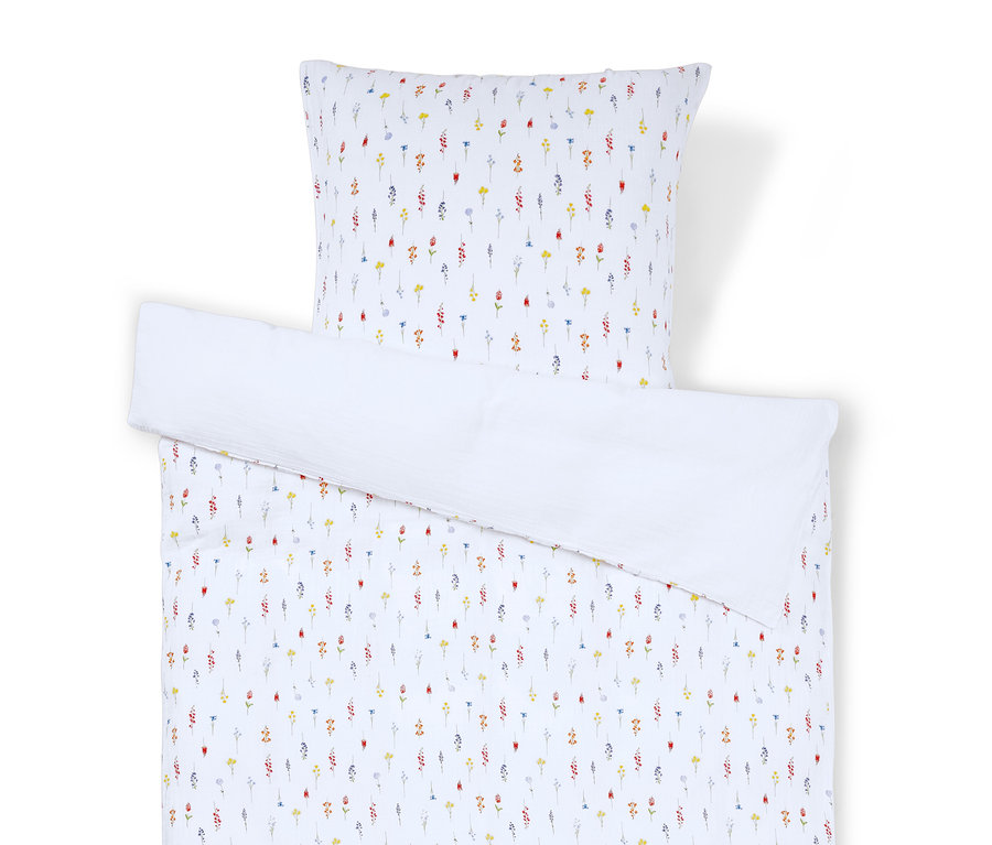 Linge de lit et taie d'oreiller à motifs floraux sur fond blanc.
