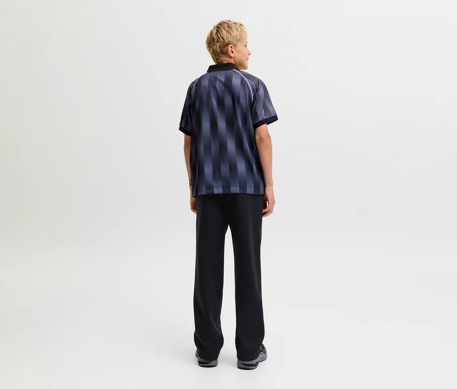 Personne de dos portant un t-shirt rayé foncé à manches courtes et un pantalon de survêtement noir Jack&Jones Bradley.