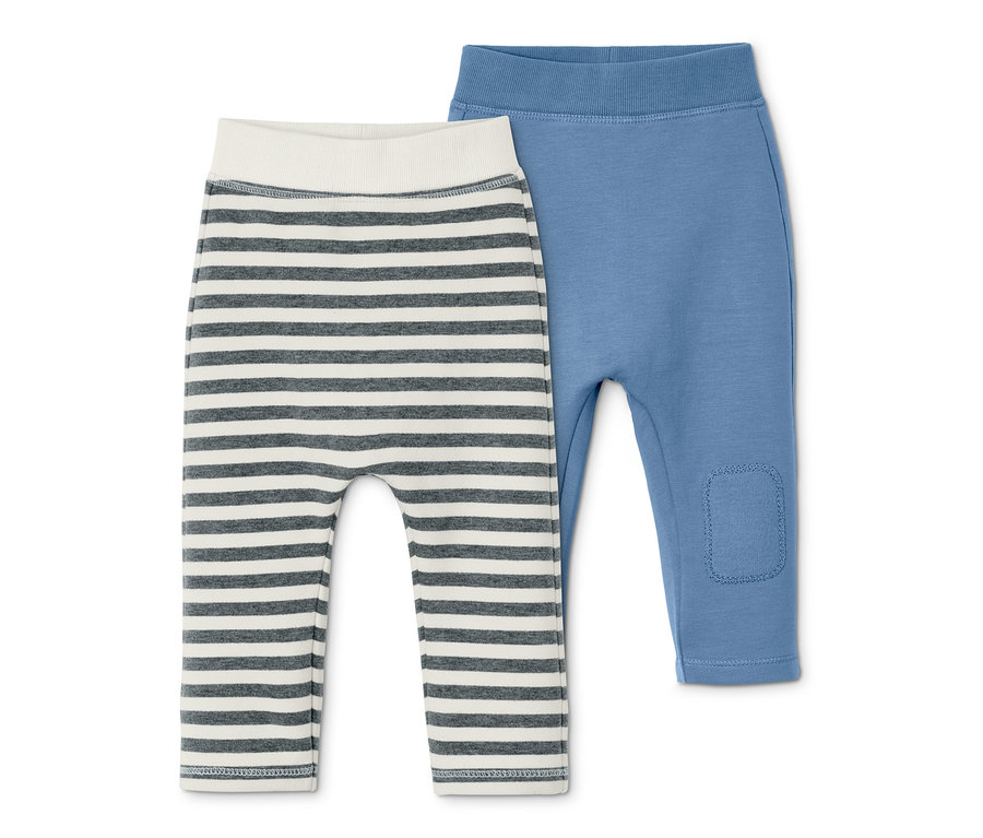Deux pantalons de survêtement en coton : un rayé gris et blanc, l'autre bleu.