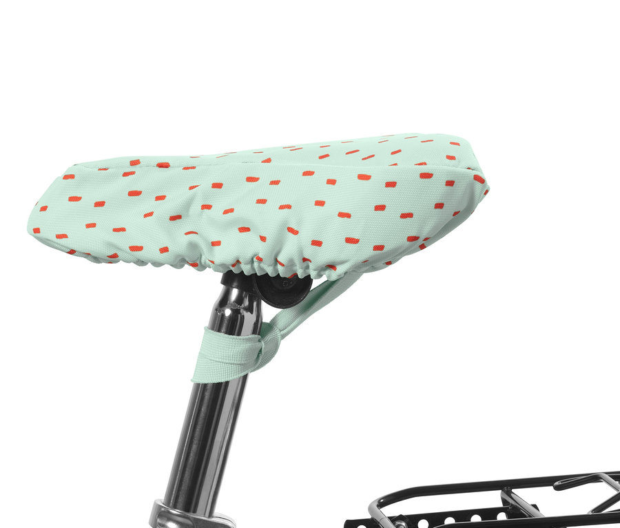 Une housse de selle de vélo pour enfants vert menthe avec des rectangles rouges.