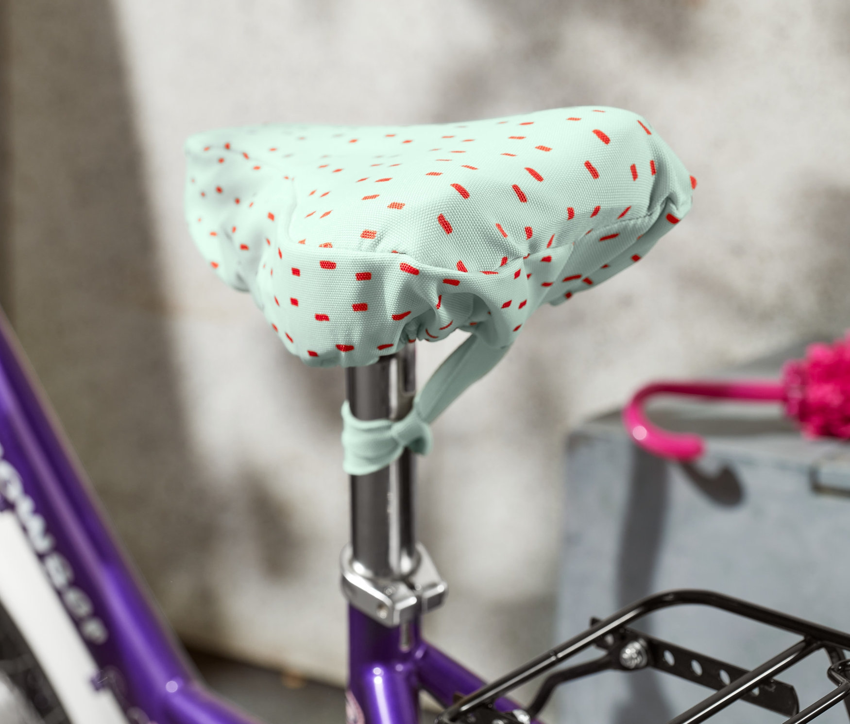 Gros plan d'un vélo violet avec une housse de selle de vélo pour enfants.