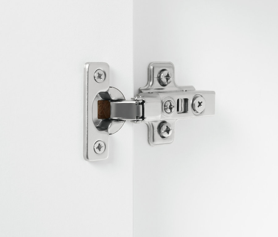 Détail d'une charnière argentée sur une armoire haute de salle de bains blanche « Eklund ».