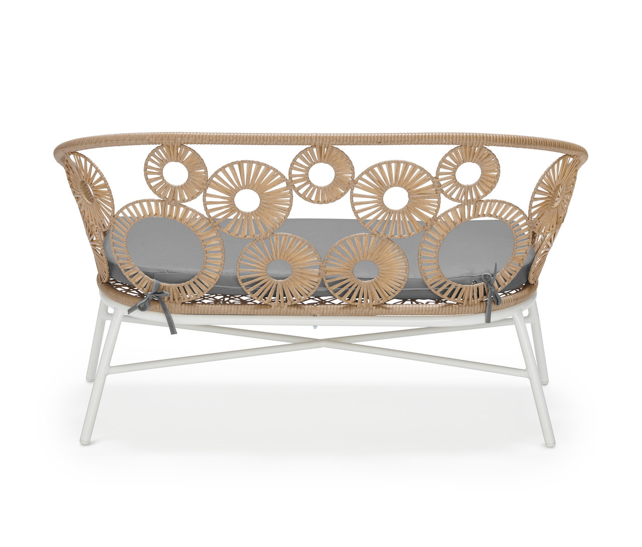 Gros plan d'un banc à motif floral avec un cadre beige et des coussins gris.
