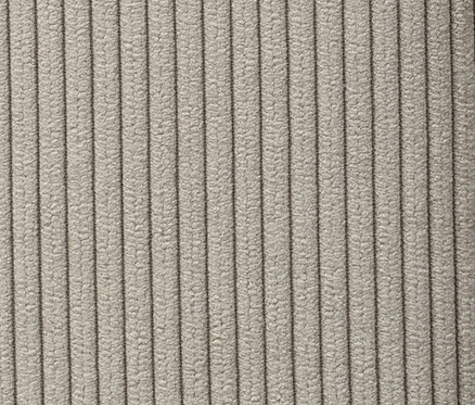 Détail d'un lit à sommier tapissier beige.