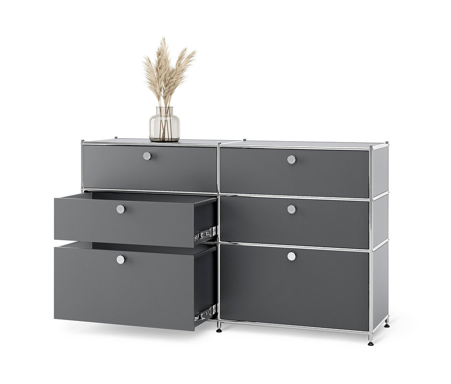Commode en métal grise « CN3 » avec 6 tiroirs dont deux ouverts et un vase avec de l'herbe dessus.