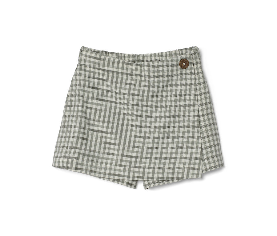 Une jupe-culotte pour enfant à carreaux avec un bouton en bois.