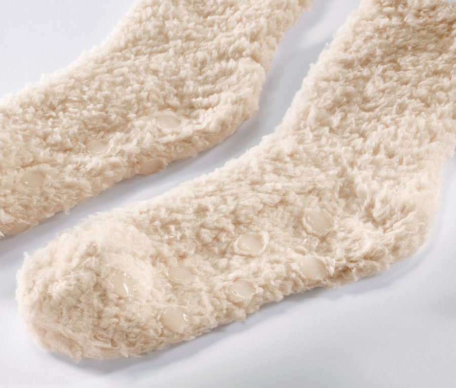 Gros plan de deux paires de chaussettes douces aspect nounours beiges.