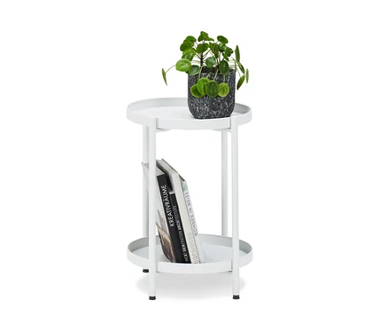 Un pot de fleurs est posé sur une table d'appoint en métal.
