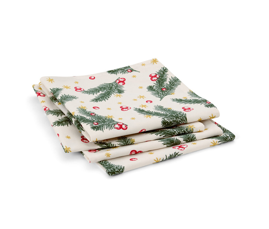 Une pile de quatre serviettes. Les serviettes sont imprimées avec des branches vertes, des baies rouges et des étoiles dorées.