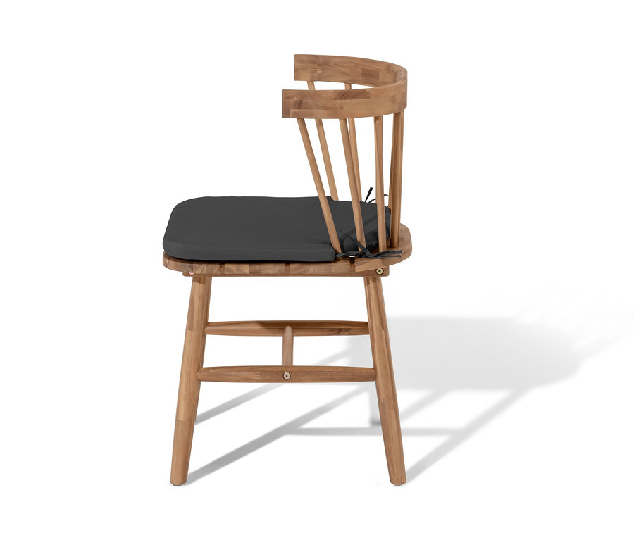 Vue latérale d'une chaise de salle à manger avec coussin d'assise sur fond blanc.