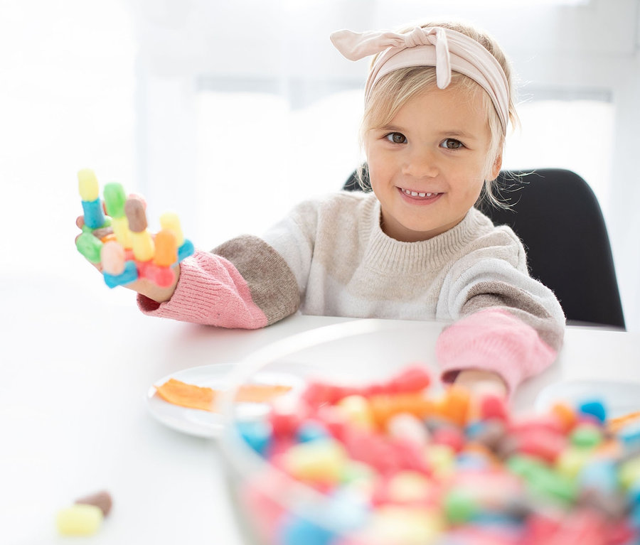 Une fille tient un ensemble coloré PlayMais® dans sa main.