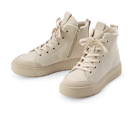Deux chaussures de sport doublées en cuir beige sur fond blanc.
