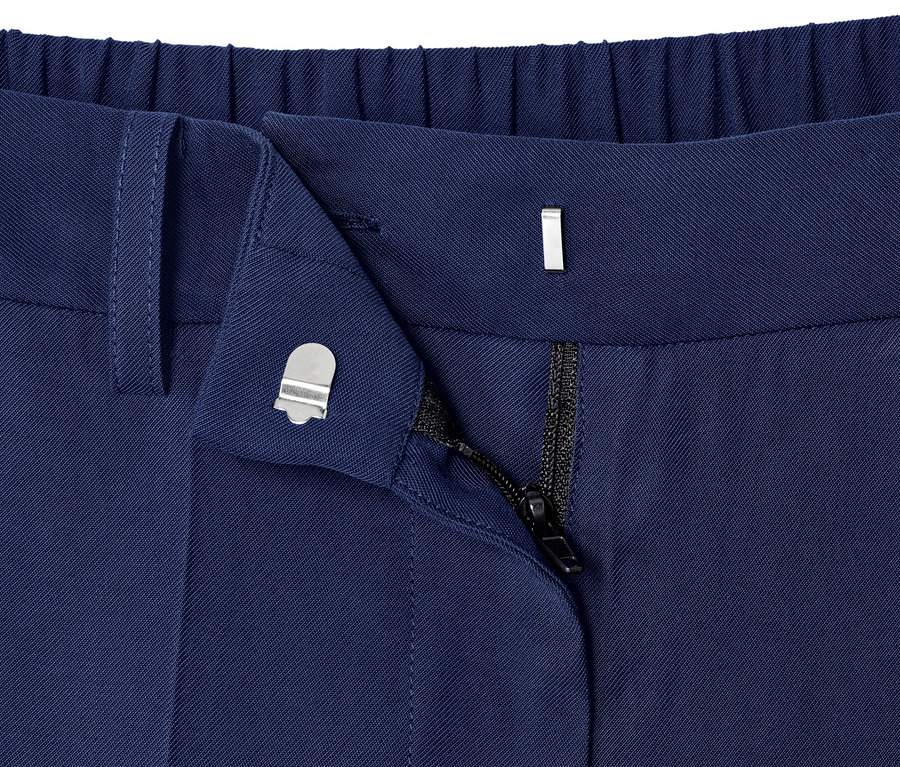 Détail d'un pantalon tissé bleu avec une fermeture éclair partiellement ouverte.